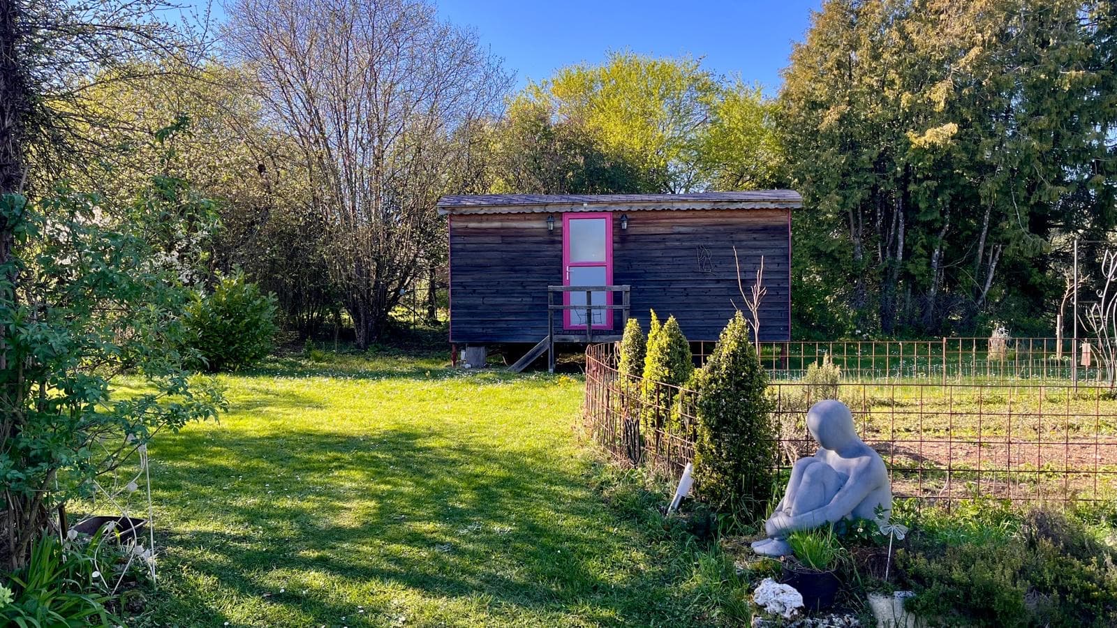 La roulotte en bois au fond du jardin